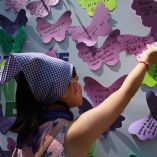 Una pequeña pega un mensaje en el que exige justicia para las mujeres