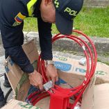 Agente de la Policía de Colombia revisa aros metálicos de baloncesto donde fueron hallados paquetes con cocaína durante una inspección en Bogotá.