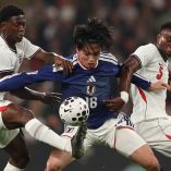 Ayase Ueda pelea un balón entre Kobbie Mainoo y Marc Guehi, de Inglaterra.