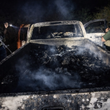 Agentes armados inspeccionan camioneta calcinada con restos en Camargo, Tamaulipas, donde fueron asesinadas 19 personas en 2021.