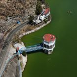 Vista aérea de presa del Sistema Cutzamala con torre de captación, camino perimetral y nivel de agua visible en temporada de estiaje
