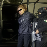 Mujer detenida por policías de Monterrey es escoltada hacia una patrulla tras ser asegurada durante un operativo en la colonia Rubén Jaramillo.