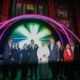 Funcionarios y asistentes posan frente a instalación luminosa del festival Glow México en el Centro Histórico de Puebla durante evento nocturno