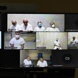 Pantallas muestran a acusados de MS-13 conectados a audiencia virtual desde cárceles en El Salvador durante juicio masivo en Soyapango.