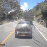 Vehículo circula detrás de un camión en vía rural de Cajibío, Cauca, mientras una persona corre tras una explosión registrada por cámara de tablero