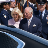 El rey Carlos III y la reina Camila descienden de un vehículo oficial en Washington, rodeados por personal militar durante su visita de Estado.