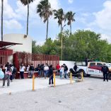 Estudiantes permanecen afuera de una escuela en Tamaulipas mientras elementos de la Guardia Estatal resguardan el acceso ante una alerta.