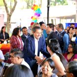 El alcalde Giovani Gutiérrez saluda a asistentes durante la feria de empleo incluyente en Coyoacán con presencia de empresas y público diverso.
