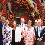 Tamara Caballero (centro), directora de Banco Multiva, afuera de la sucursal de Masaryk adornada con flores.