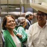 Roberto Sánchez sonríe junto a una mujer en un ascensor tras atender a la prensa en Lima durante el proceso electoral peruano de 2026.