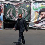 Un hombre pasa junto a pancartas colocadas a lo largo de la carretera con la imagen del ayatolá Ali Khamenei