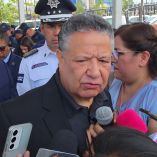 Julio Menchaca habla ante medios rodeado de policías y funcionarios en Pachuca durante un evento público de seguridad estatal
