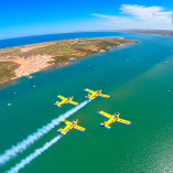 Cuatro aviones Zlin 242L de la SEMAR sobrevuelan en formación cerrada sobre el mar durante prácticas de la Escuela de Aviación Naval.