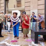 Clara Brugada, jefa de Gobierno de la CDMX, barriendo con agua y jabón una calle del Centro Histórico junto a ciudadanos y comerciantes durante un tequio de limpieza.