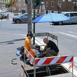Trabajadores reparan cables de telecomunicaciones bajo extenuante el sol en Roma, Italia.
