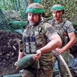 Un integrante de la 15.ª Brigada Kara-Dag de Ucrania carga un proyectil.