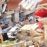 Una venezolana camina entre los escombros de un edificio destruido por los sismos.