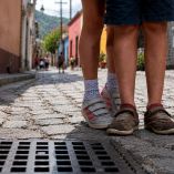 Dos niñas caminan por una calle empedrada, imagen representativa de menores en condición de orfandad y la necesidad de apoyo integral.