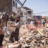 Hombre cargando una caja con escombros durante las labores de limpieza por el temblor en Colombia.