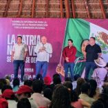 Asamblea informativa en Playa del Carmen con asistentes frente a un escenario que muestra mensajes sobre transformación y soberanía nacional.