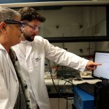 Nieves Casañ-Pastor y Marc Mosqueda, investigadores del CSIC, observan datos de pruebas sobre baterías en un laboratorio.