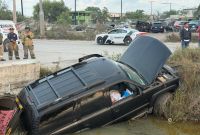 Camioneta Chevrolet Tahoe volcada dentro de un canal pluvial al sur de Matamoros, Tamaulipas, tras un accidente vial; en el lugar se observa la unidad siniestrada y la presencia de autoridades y cuerpos de emergencia.