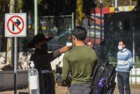 Personal de seguridad de la UAEMÉX toma la temperatura a un estudiante al ingreso a Ciudad Universitaria en Toluca, como parte de las medidas sanitarias reforzadas ante el riesgo de transmisión de sarampión y enfermedades respiratorias en febrero de 2026.