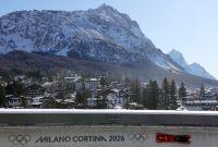 Vista del Cortina Sliding Centre en Cortina d’Ampezzo durante un entrenamiento oficial de bobsleigh de los Juegos Olímpicos de Invierno Milano Cortina 2026, con un trineo en la pista y montañas nevadas al fondo.