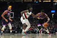 El escolta de los Timberwolves, Anthony Edwards, dribla ante la marca de Jrue Holiday, de  los Trail Blazers.