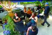 Momento en que el asaltante saca de entre sus prendas lo que parece ser una pistola para amenazar a sus víctimas.