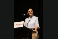 Ariadna Montiel Reyes habla en un podio con logotipo de Bienestar durante un evento oficial, frente a micrófono en escenario interior