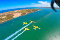 Cuatro aviones Zlin 242L de la SEMAR sobrevuelan en formación cerrada sobre el mar durante prácticas de la Escuela de Aviación Naval.
