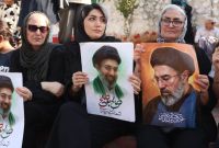 Mujeres iraníes sostienen retratos de Mojtaba Jamenei.