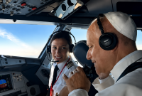 El papa León XIV con auriculares conversa con una piloto en la cabina de un avión durante el trayecto entre Madrid y Barcelona.