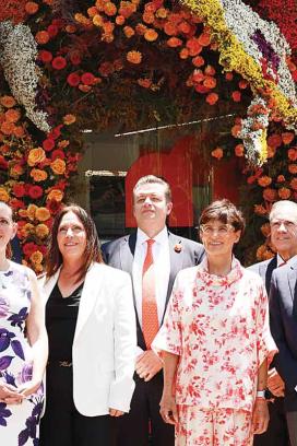 Tamara Caballero (centro), directora de Banco Multiva, afuera de la sucursal de Masaryk adornada con flores.