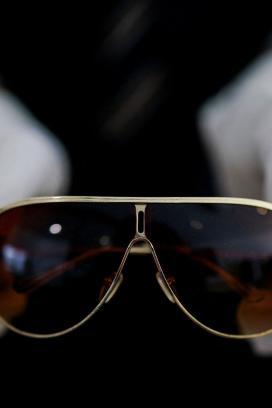 Gafas aviador de Michael Jackson sostenidas con guantes blancos durante presentación previa a subasta en Aguttes, Francia, abril de 2026