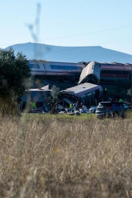 Varios vagones de tren descarrilados en Urda, Toledo, mientras equipos de emergencia y personal de rescate trabajan junto a las vías.