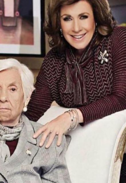 Laura Zapata con traje vino abrazando a abuela Eva Mange