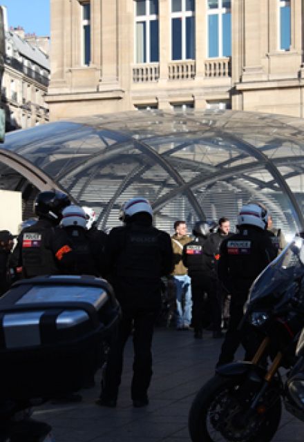 Agentes de la policía revisan a un grupo de jóvenes manifestantes a la salida de una estación de metro, el sábado por la mañana.