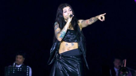 Cazzu canta con micrófono durante un concierto tras sus declaraciones sobre la Ley Cazzu.