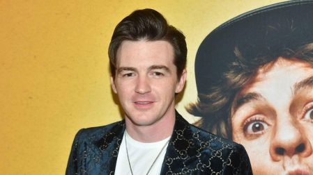 Drake Bell con saco negro estampado y camiseta blanca durante un evento, tras denunciar la negativa de seguro médico de SAG-AFTRA.