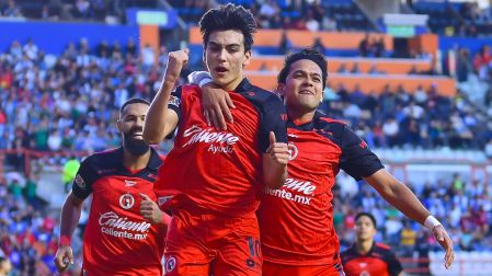 Gilberto Mora celebra con playera especial, luciendo 'Caliente ayuda' como patrocinador principal.