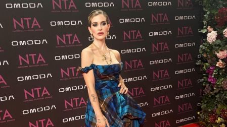 Kelly Osbourne posa con vestido azul de cuadros y cabello recogido sobre la alfombra roja de los National Television Awards.