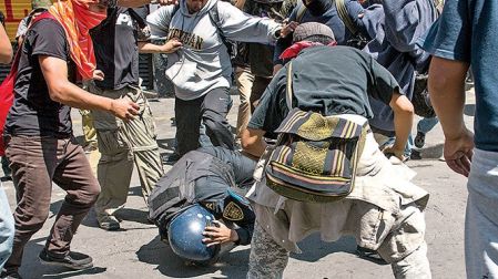 Un policía es agredido, el pasado 1 de septiembre, en una de las protesta de los integrantes de la CNTE.