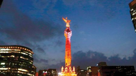 Monumentos emblemáticos de la CDMX, como el Ángel de la Independencia, se iluminaron de naranja ayer, por el Día Internacional de la Eliminación de la Violencia contra la Mujer.    Foto: Cuartoscuro