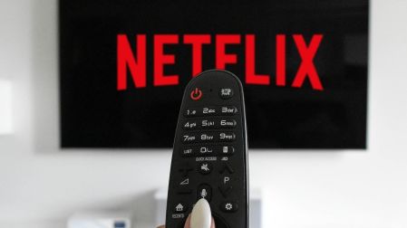 Imagen de una pantalla con el logo de Netflix y en primer plano un control