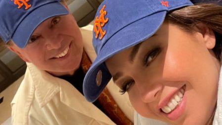 Tommy Mottola y Thalía sonriendo con gorras azules de Nueva York