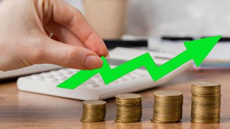Gráfico que muestra el crecimiento económico a través de una mano que pone monedas en varias columnas.