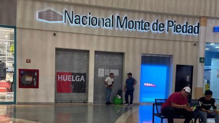 Sucursal del Monte de Piedad con una bandera rojinegra de huelga en la entrada