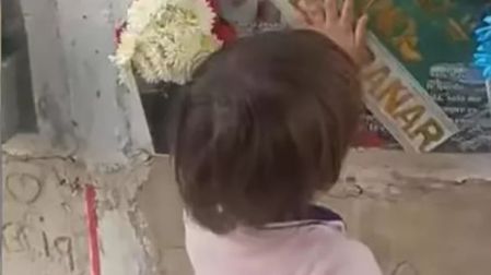 Niño visita la tumba de su papá